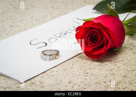 Concepto de perdida de relación con una carta, una rosa roja y un anillo de compromiso en una mesa izquierda Foto de stock