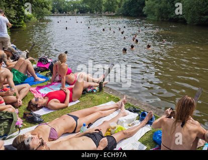 Las personas tomando el sol en la Hampstead Heath estanque mixto en Londres, Gran Bretaña. Foto de stock