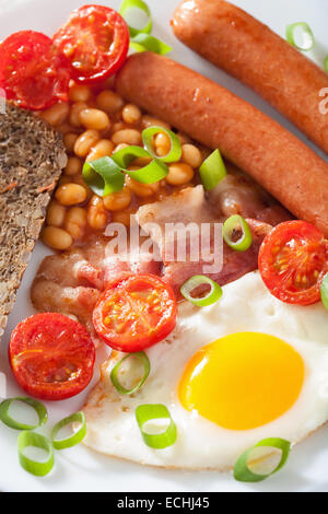 Desayuno inglés con huevo frito las salchichas bacon tomates frijoles Foto de stock
