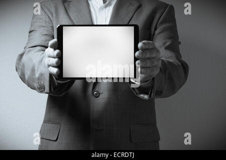 La imagen muestra una persona vestida con un traje sosteniendo un equipo tablet PC. Sólo el cuello de la persona, que es visible en la cintura Foto de stock