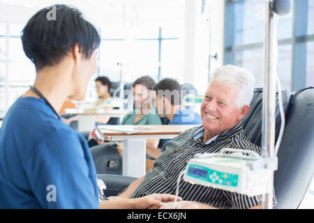Altos paciente sometido a tratamiento médico a hablar con el doctor en la clínica ambulatoria Foto de stock