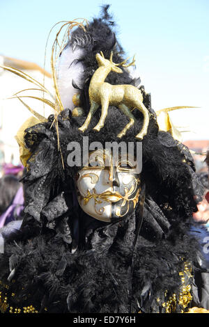 Un hombre veneciano con una máscara de oro y traje negro Fotografía de  stock - Alamy
