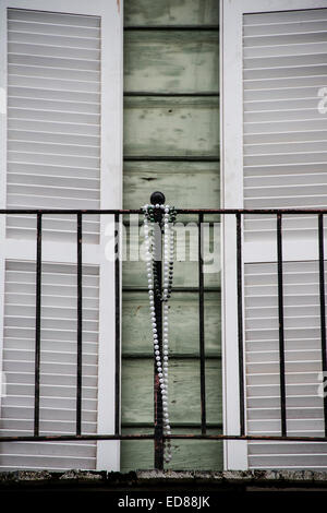 Mardi Gras beads colgados en las parrillas de hierro de un balcón residencial en Nueva Orleans, Luisiana Foto de stock