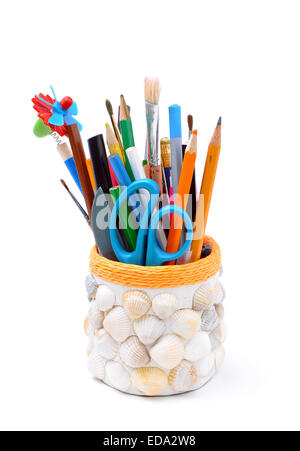 Lápices, pinceles, cuchillo de plástico, unas tijeras en la mano lápiz-box aislado Foto de stock