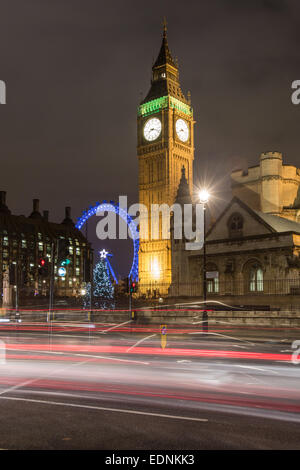 Las casas del parlamento, el Big Ben y el London Eye de noche con rayas de tráfico.