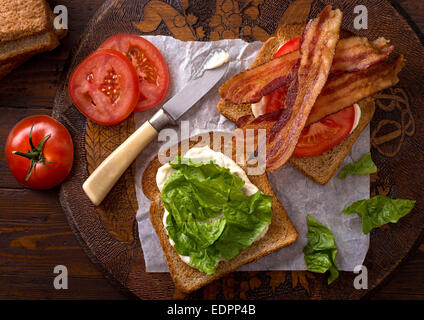 Un delicioso BLT bacon, lechuga y tomate sándwich en rústica mesa. Foto de stock