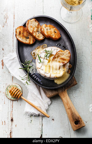 El Camembert queso cocido con pan tostado en sartén de hierro fundido Foto de stock