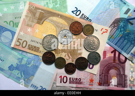 Una mezcla de viejas monedas dracma que rodean el mapa de Europa en una nota de papel 50 euro. Foto de stock