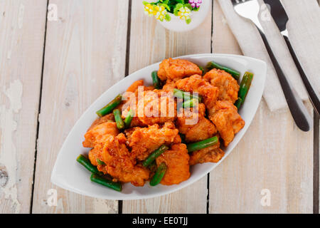 Trozos de pollo rebozados con salsa picante y judías verdes Foto de stock