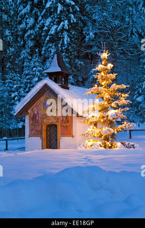 Beleuchteter Christbaum vor einer Kapelle en Bayern Foto de stock