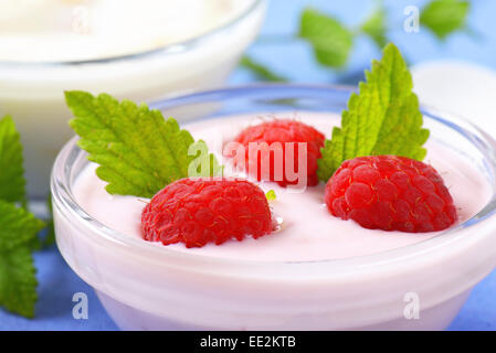 Luz blanca de frambuesa y yogur en recipientes de cristal Foto de stock