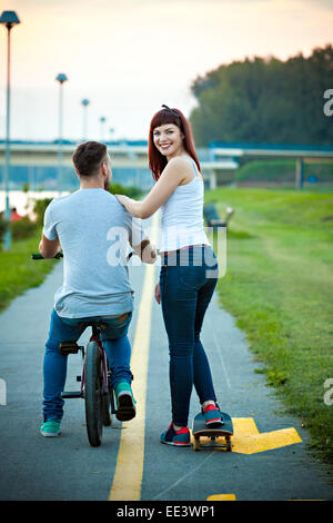 Pareja joven con bicicleta BMX y skate al aire libre Foto de stock