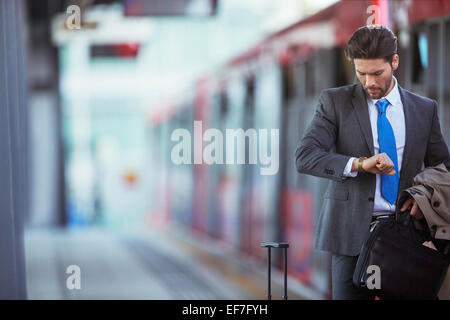 El empresario controlar su reloj en la estación de tren Foto de stock