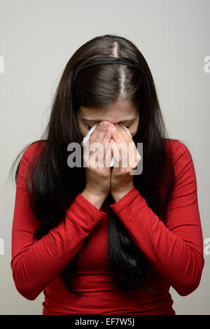 Mujer llorando y limpiando las lágrimas con un pañuelo de papel