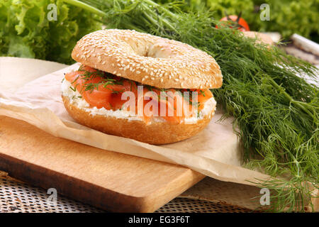 Sandwich con salmón ahumado y eneldo sobre una tabla de cortar