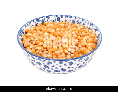 Maíz para palomitas en un bol de cerámica blanca sobre fondo blanco, vista  desde arriba Stock Photo