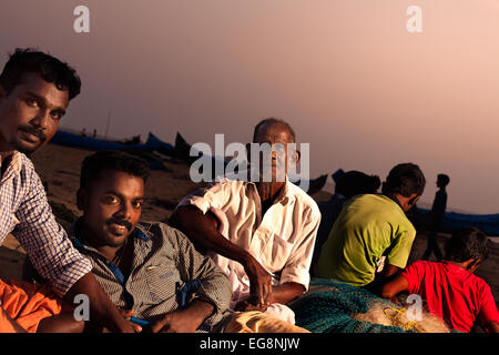 Los pescadores indios relajarse al final del día en la playa de Cherai en el sur de la India.