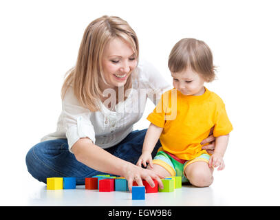 La madre y el bebé jugar con bloques de construcción toy aislado en blanco