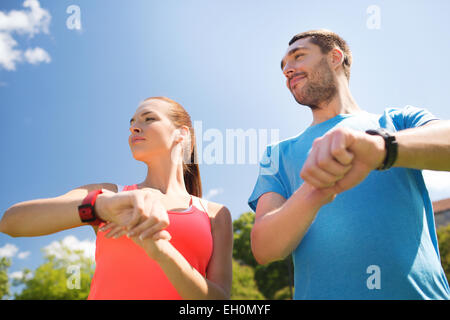Gente sonriente con ritmo cardíaco relojes outdoors Foto de stock