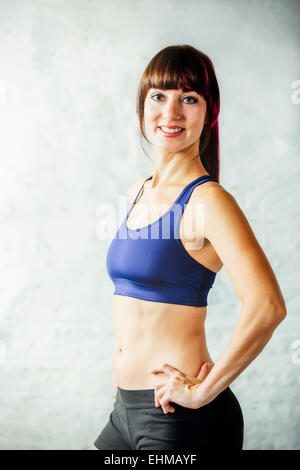 Mujer caucásica sonriente en un sujetador deportivo