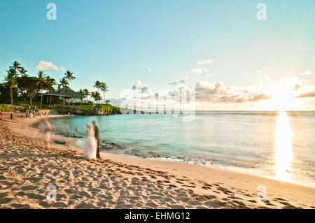 MAUI, Hawaii - Septiembre 4, 2013: la larga exposición de las parejas que se casan no identificados al atardecer en la playa de Kaanapali en Maui. Mo Foto de stock