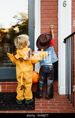Los muchachos en trajes truco o tratar juntos en Halloween Foto de stock