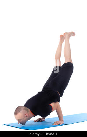 Athletic hombre haciendo yoga pino en studio Foto de stock