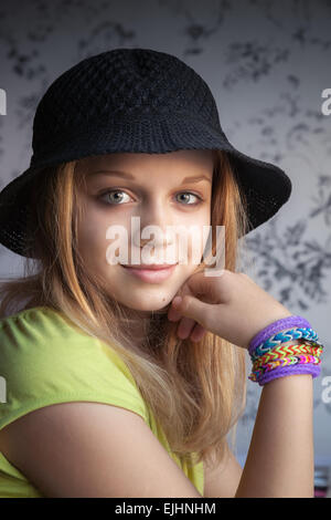 Retrato de hermosa rubia chica adolescente en un sombrero negro y caucho pulseras telar Foto de stock