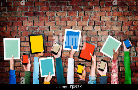 Manos sosteniendo los dispositivos digitales con pantallas coloridas Foto de stock