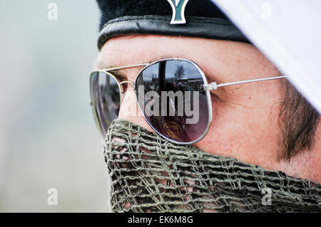 Un hombre enmascarado llevaba una lona sobre su boca, gafas de sol y una boina negra es parte de un republicano irlandés conmemoración Foto de stock