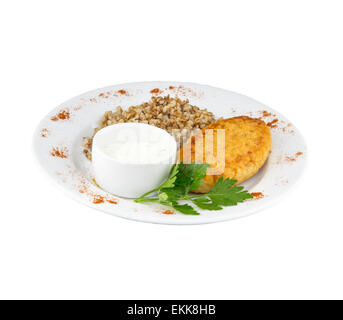 Gran chuleta de pollo con salsa y el alforfón en una placa con un fondo aislado