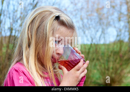 Cerca del niño chica rubia bebiendo limonada fuera del horario de verano Foto de stock