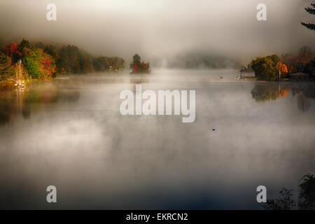 Un alto ángulo de visualización de un lago con niebla matutina durante el otoño, Knapp Brook Pond, Vermont Foto de stock