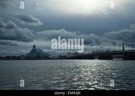 Biblioteca Nacional a orillas del río Daugava en Riga a principios de la primavera con bellas nubes en el cielo azul Foto de stock