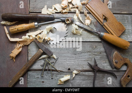 Vista superior de la mesa de carpintero. Oxidado viejo y sucio herramientas manuales del carpintero acostado sobre la mesa de madera con aserrín. Foto de stock
