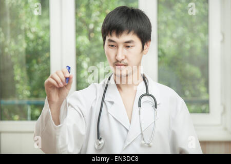 Indicado por el médico, un hombre en una bata blanca apunta un dedo en la oficina Foto de stock