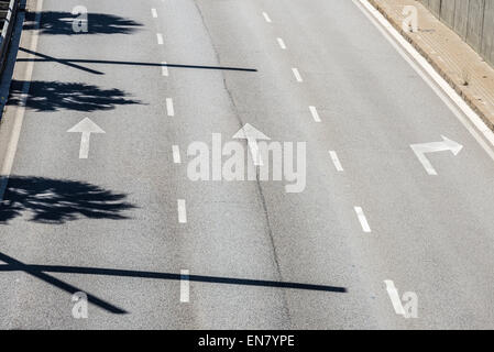 Flechas de dirección y las líneas discontinuas en el asfalto Foto de stock