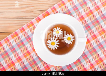 Taza de té de manzanilla natural y flores en la mesa blanca cerca de la  pared azul Fotografía de stock - Alamy