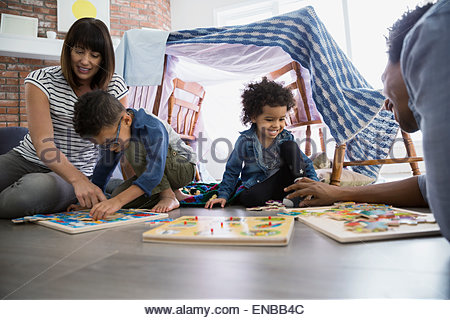 Familia jugando con los rompecabezas en el piso