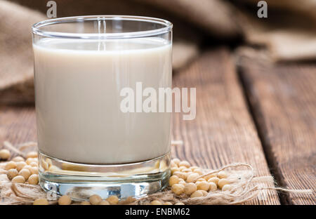 Vaso con leche de soya y las semillas sobre fondo de madera Foto de stock