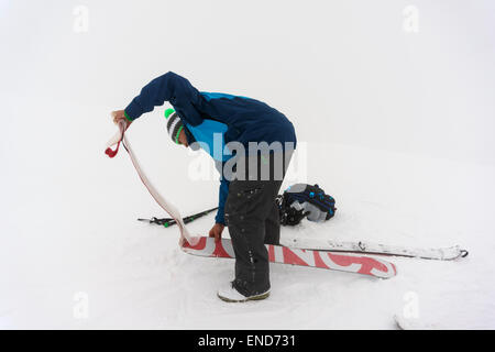 Un hombre quitar las pieles de un splitboard sobre la cumbre de Fastdalstinden, Lyngen Alpes, Noruega Foto de stock