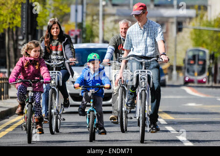 Belfast, Irlanda del Norte. 26 Abr 2015 - Una familia se encuentran entre un número de personas que resultó ser el primer viaje del nuevo público alquilar bicicletas en Belfast.