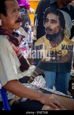 Hombre vestido con una camisa decorada con el retrato de Bob Marley durante una reunión comunitaria en la isla de Sumba, Indonesia. Foto de stock