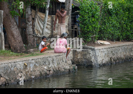 India, Kerala, Alleppey. Canales de remanso de Kerala en el área de Kumarakom, conocida como la 'Venecia de Oriente'. Mujer pesca.