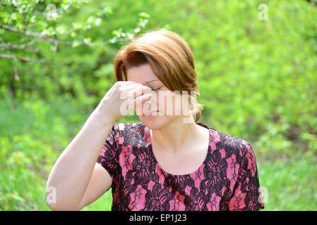 Mujer con rinitis en el verano park Foto de stock
