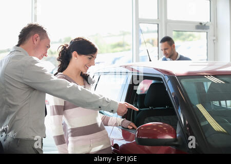 Concesionario de automóviles hacia el interior de un coche con una mujer Foto de stock