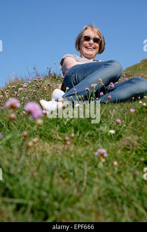 Senior mujer recostada sobre la hierba