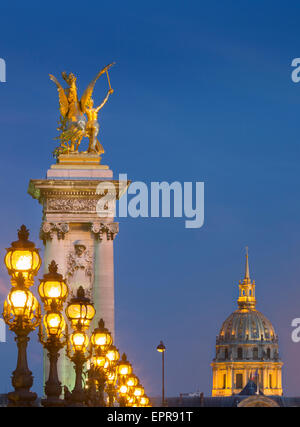 Fila de farolas a lo largo Puente Alexandre III con cúpula del Hotel des Invalides más allá, París, Francia