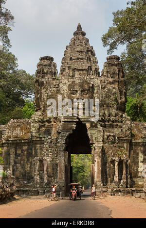 La victoria en la puerta este de Angkor Thom, tuk-tuk, Avalokiteshvara cara tower, East View, Angkor Thom, Siem Reap, Camboya Foto de stock