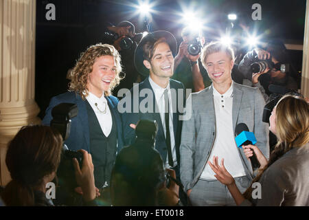 Celebridades sonriente entrevistada y fotografiada por fotógrafos paparazzi en el evento